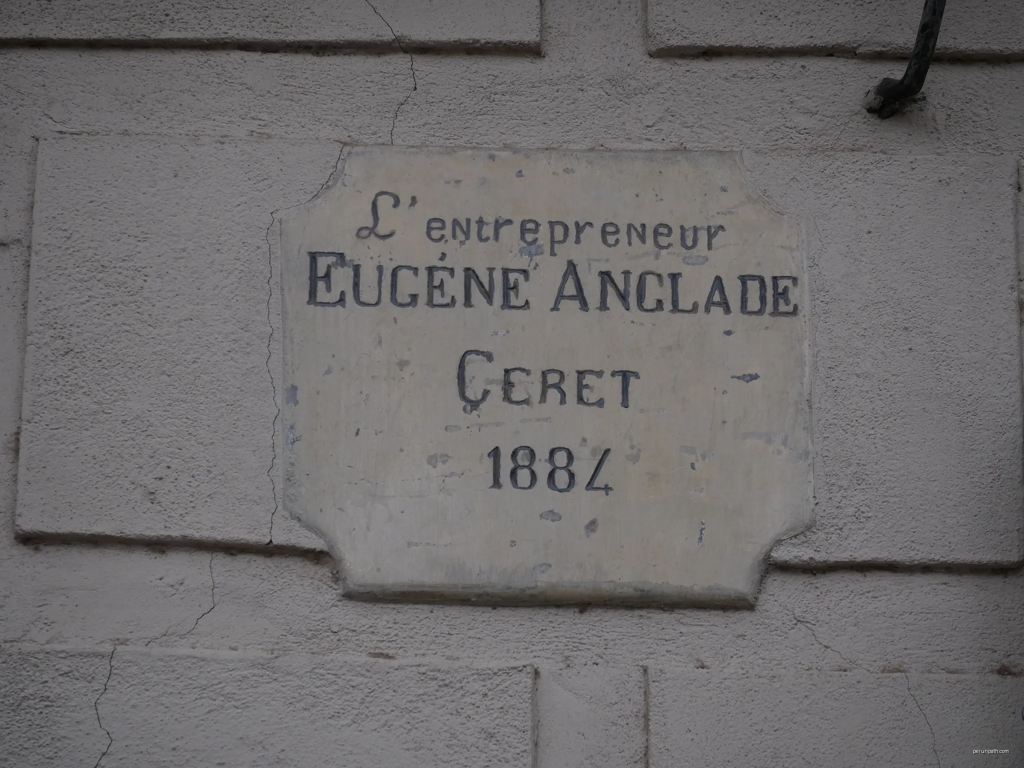 Plaque indiquant la construction par l'entrepreneur Eugène Anglade en 1884 au n°25 Boulevard Maréchal Joffre à Céret. | Autor: Fabricio Cardenas | Licencja: CC BY-SA 4.0 | Źródło: Wikimedia Commons