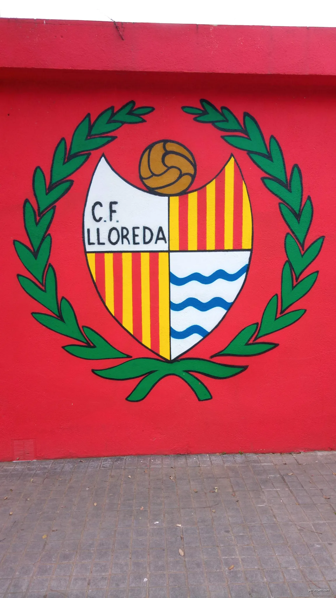 Escut del CF Lloreda, situat al camp de futbol del club. | Autor: PatriaHannibalis | Licencja: CC BY-SA 4.0 | Źródło: Wikimedia Commons