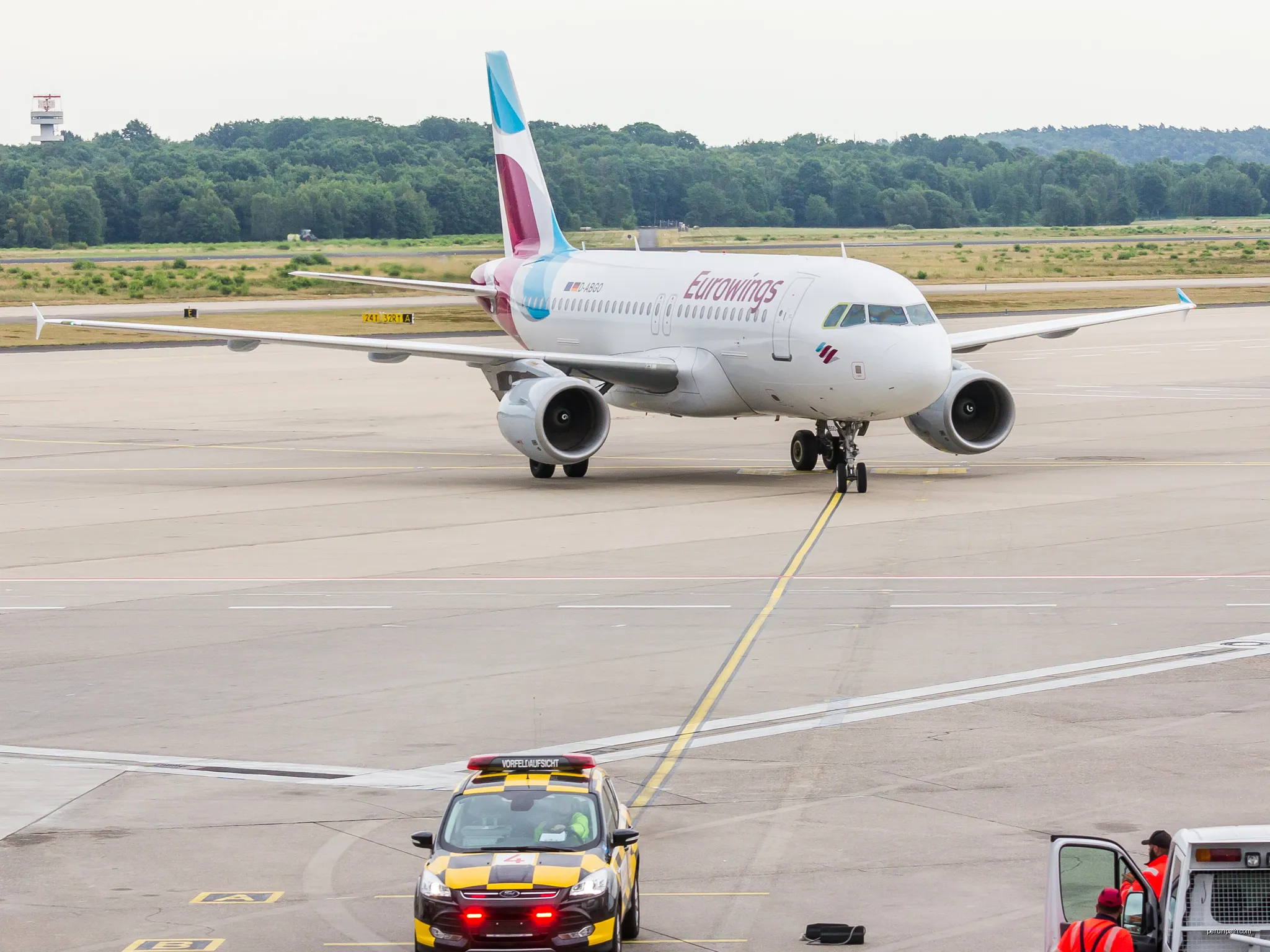 Eurowings - Airbus A319 - D-ABGO - Cologne Bonn Airport - with Follow me car | Autor: Raimond Spekking | Licencja: CC BY-SA 4.0 | Źródło: Wikimedia Commons