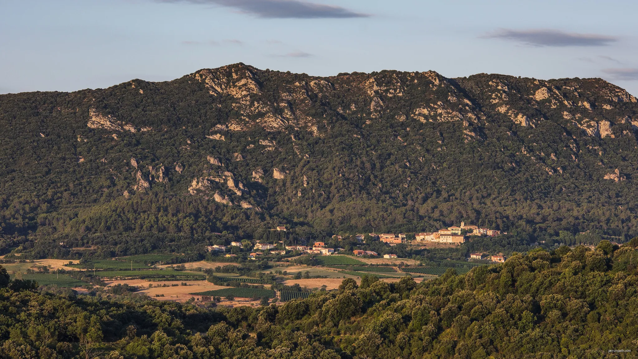 The Mount Liausson and the village of Liausson from the commune of Clermont-l'Hérault, Hérault, France | Autor: Christian Ferrer | Licencja: CC BY-SA 4.0 | Źródło: Wikimedia Commons