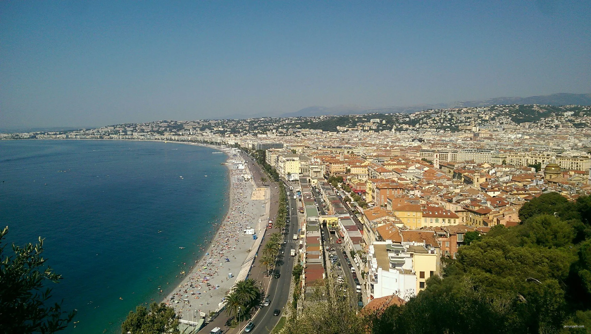 Vue du parc du château de Nice sur la plage et vielle ville | Autor: Yaël T. | Licencja: CC BY 4.0 | Źródło: Wikimedia Commons
