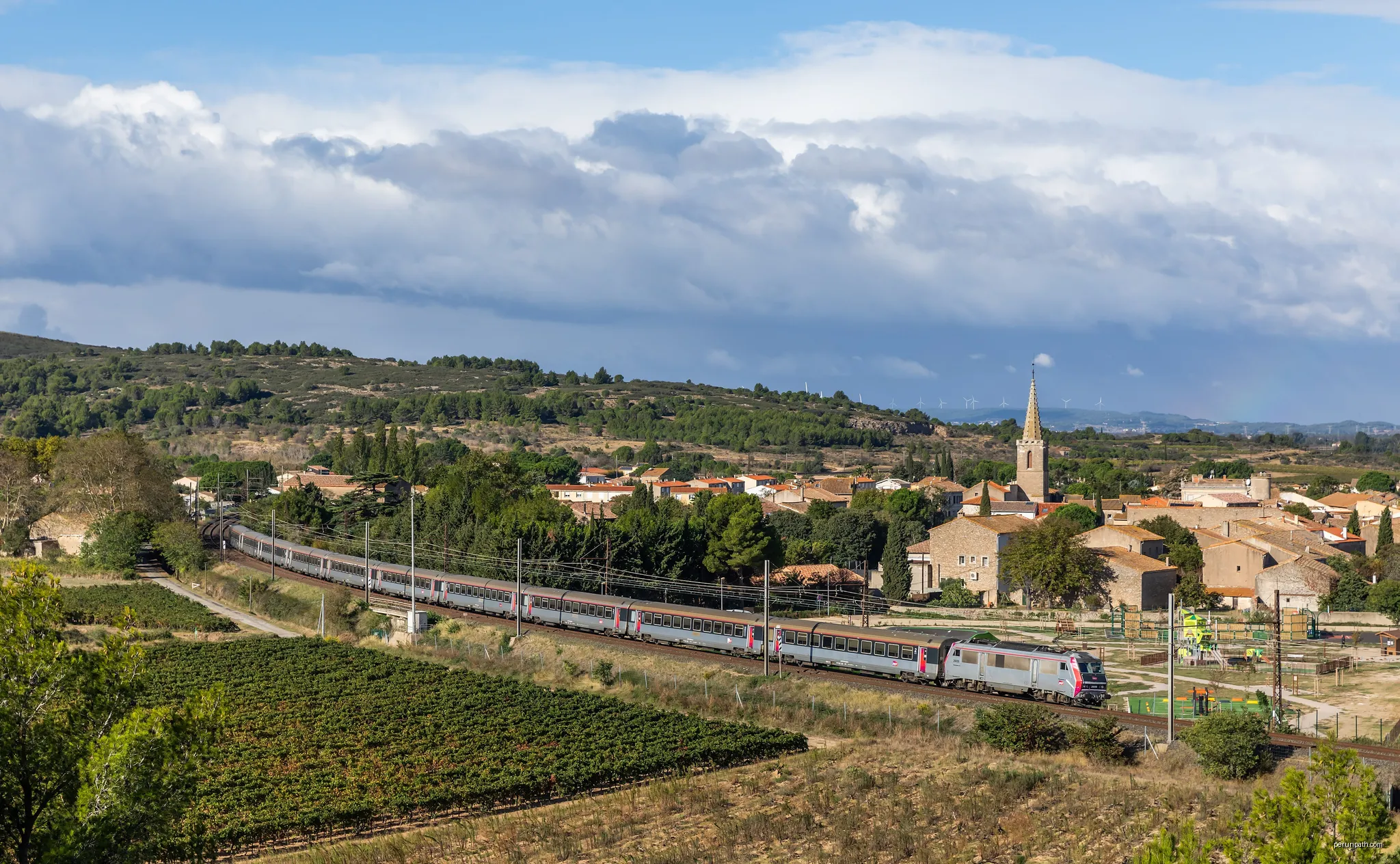 SNCF's "SyBic" BB 26074 with IC 4655 Bordeaux Saint-Jean - Marseille Saint-Charles passing the town of Névian, France. | Autor: Kabelleger | Licencja: CC BY-SA 4.0 | Źródło: Wikimedia Commons