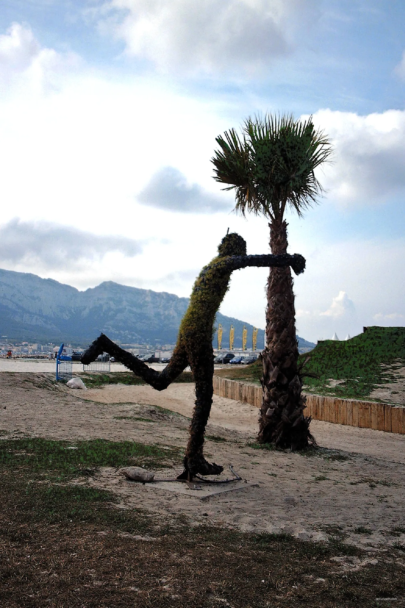 The photograph of the "tree man" who appears to be kicking a palm tree was a temporary feature on the Plage du Prado, Marseille in 2008 | Autor: Compo | Licencja: CC BY-SA 4.0 | Źródło: Wikimedia Commons