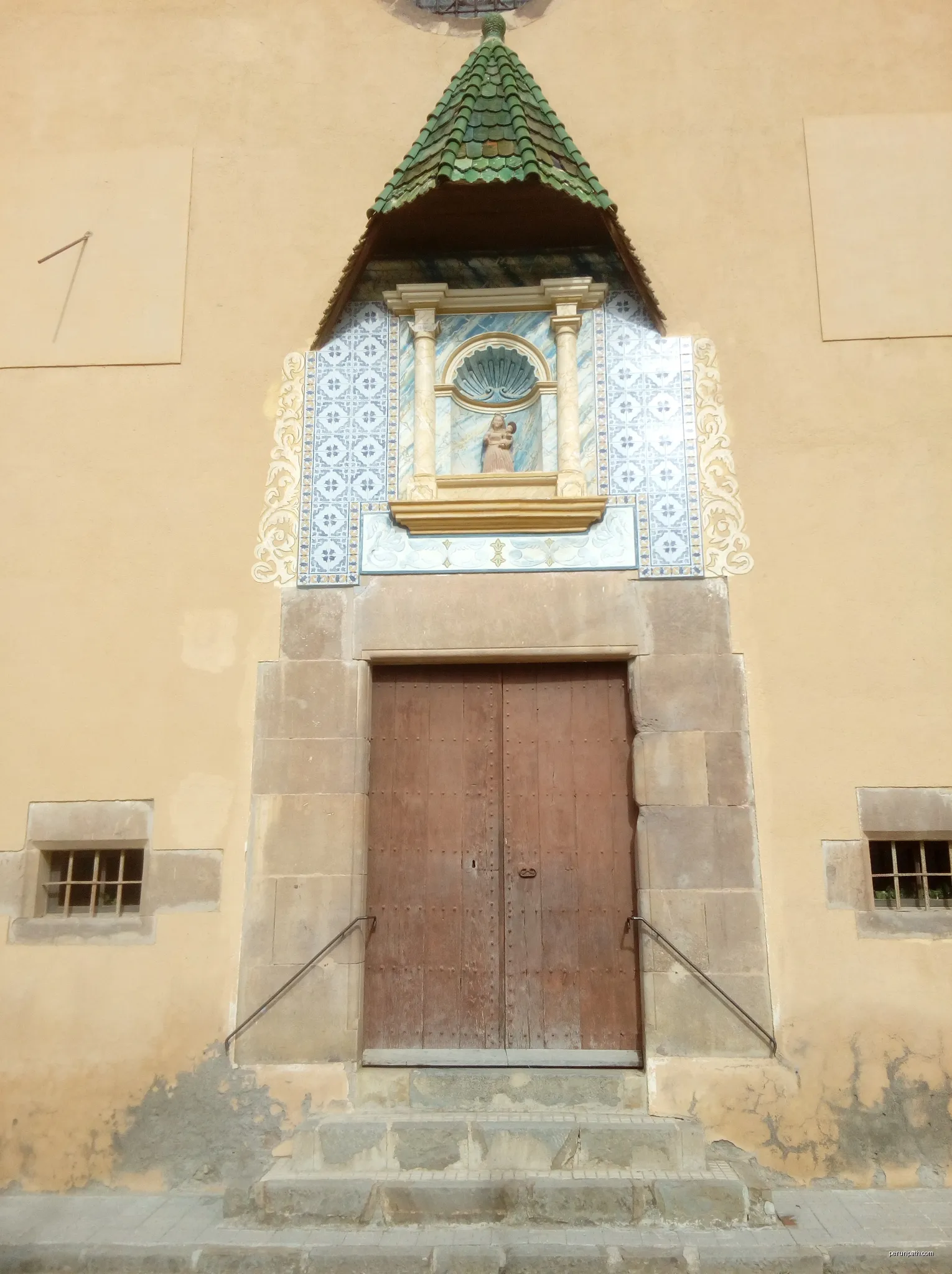 Front of door of the chapel near the town hall, Vallfogona de Ripollès, Spain | Autor: Jack_ma | Licencja: CC BY-SA 4.0 | Źródło: Wikimedia Commons