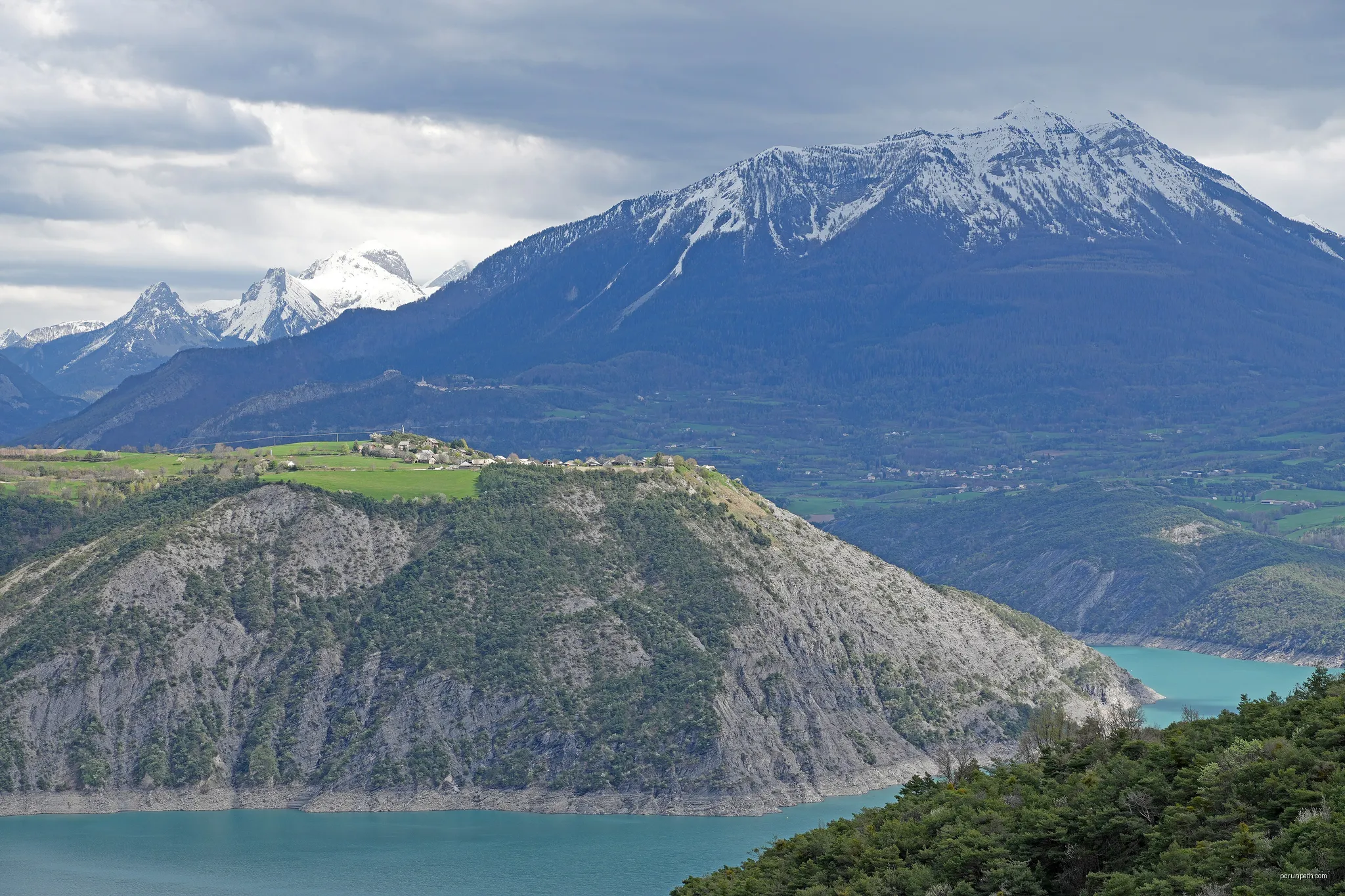 Village du Sauze du lac suplombant le lac deSerre-Ponçon avec en arière plan le sommet de Dormillouse 2500 metres  (Hautes Alpes, France) | Autor: Pline | Licencja: CC BY-SA 4.0 | Źródło: Wikimedia Commons