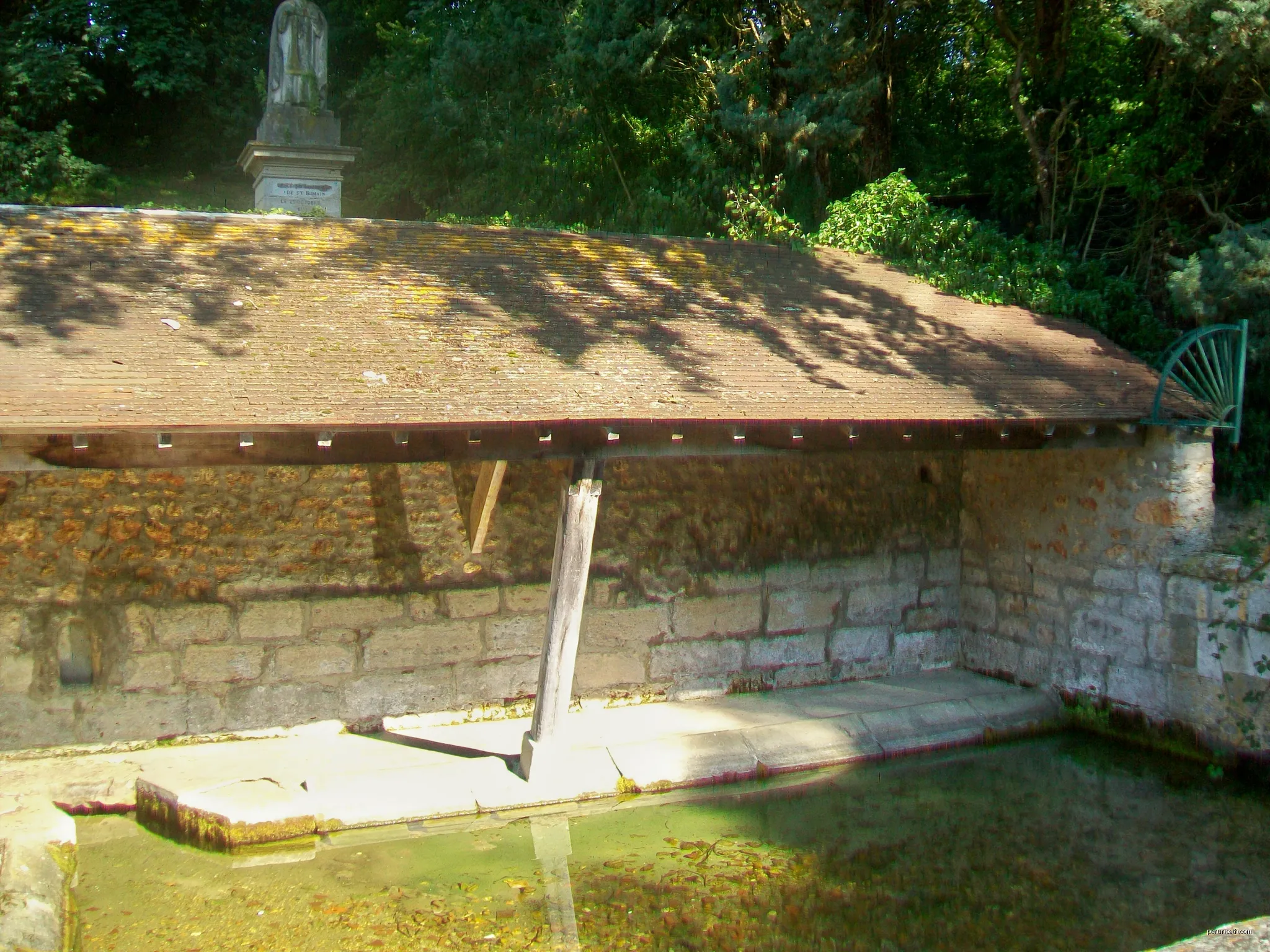 La fontaine Saint-Romain, aménagée en lavoir, accompagnée d'un abreuvoir et surplombée par une statue de Saint-Romain. Près de la RD 159 entre Guiry et Wy. | Autor: P.poschadel | Licencja: CC BY-SA 3.0 | Źródło: Wikimedia Commons